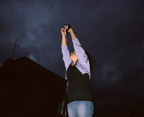 Image of woman photographing a blackened sky